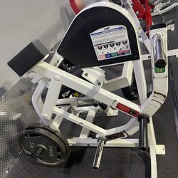 Busy Body Fitness Center - Target loading, old school leg extension + plate loading single leg press (red machine in the background)