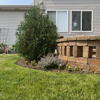 Quintessential Lawn Care - a brick retaining wall and flower bed - Lawn Services Near Me Quintessential Lawn Care - a brick retaining wall and flower bed - Lawn Services Near Me