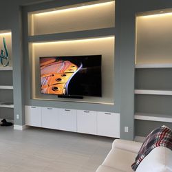 Next Step Communications - Large TV installed in TV recess. 5.1 surround sound in-ceiling speakers/Subs with all in one remote to hidden equipment in closet rack.
