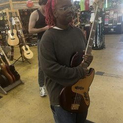 Corner Music - My Princess shopping for a Jazz Bass Guitar with our favorite sales associate Ben. (Not the guy photobombing )