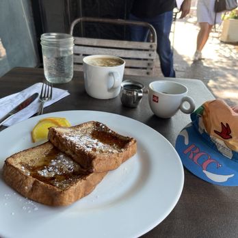 Rosie - Tasteless French toast, a supposed flat white and a Rapha RCC cycling cap. Also people's legs, table and chair along with a window. - American Near Me - New Canaan, Connecticut Rosie - Tasteless French toast, a supposed flat white and a Rapha RCC cycling cap. Also people's legs, table and chair along with a window. - American Near Me - New Canaan, Connecticut