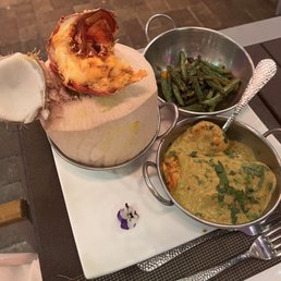 Lobster, shrimp, scallops, salmon served in a coconut shell, and green beans. Lobster, shrimp, scallops, salmon served in a coconut shell, and green beans.
