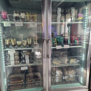 Bean and Blend Cafe - Drinks - A glass-front refrigerated display case contains various desserts, including parfaits, cakes, and packaged snacks, with labels and pricing. - Coffee & Tea Near Me - Tabernacle, New Jersey