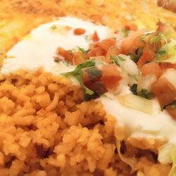 Mr Delicious - Spanish rice and refried beans close up with shredded lettuce, pico, and sour cream