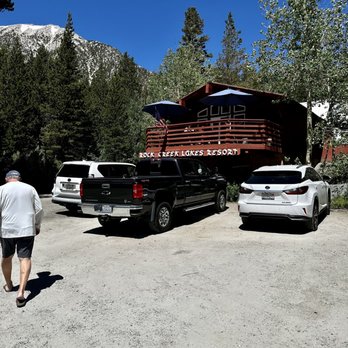 Rock Creek Lakes Resort - The front of Rock Creek Cafe. They have an outside patio with three tables, a few tables indoors, and a picnic table by stream. - Hotels Near Me - Bishop, California
