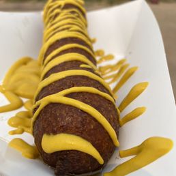 a hot dog covered in mustard