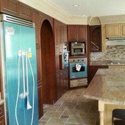 All Around Handyman Company - A modern kitchen featuring wooden cabinetry, granite countertops, and built-in stainless steel appliances...