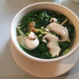 a bowl of soup with mushrooms and spinach