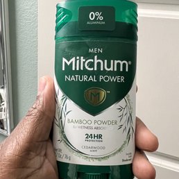 a hand holding a bottle of mitchum a hand holding a bottle of mitchum