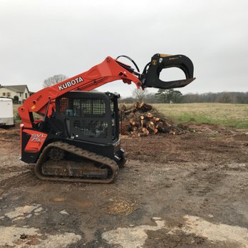 Prime Green Landscaping & Tree Service - a bobcat excavating a pile of wood - Tree Services Near Me Prime Green Landscaping & Tree Service - a bobcat excavating a pile of wood - Tree Services Near Me