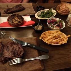 Ô QG - Sirloin in front, hanger steak in the back, with sides of duck fat fries, salad, green beans, and gratin potatoes