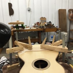 Dey Martin Guitars & Repair - Clamping to re-glue loose back brace. There is a jack inside the body to prevent collapse and to transfer pressure to brace.