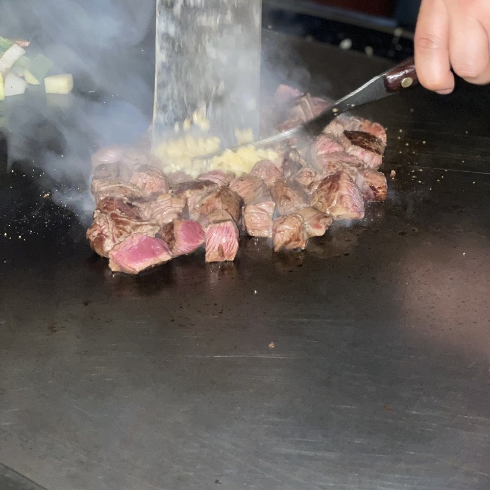 a steak being cooked on a grill with smoke coming out of it