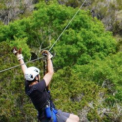 Wimberley Ziplines Adventures - Man zipping high above treetops