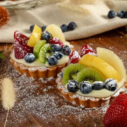 Delicious Bakery - A buttery crust, creamy custard, and fresh kiwi, berries, and peach, dusted with sugar--this fruit tart is an irresistible treat!