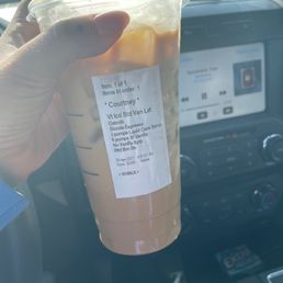 a hand holding a cup of iced coffee