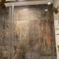 Kohler Signature Store - Special order Elenco Oxido on larger shower wall, Amalfi Calcatta on two other walls. All fixtures are Vibrant Brushed Moderne  Brass.