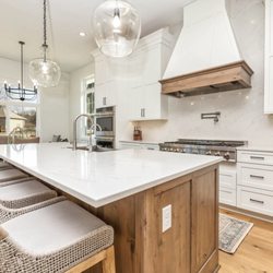 Benson Stone Company - Kitchen design with island, white quart countertops, backsplash, and glass globe pendant lighting