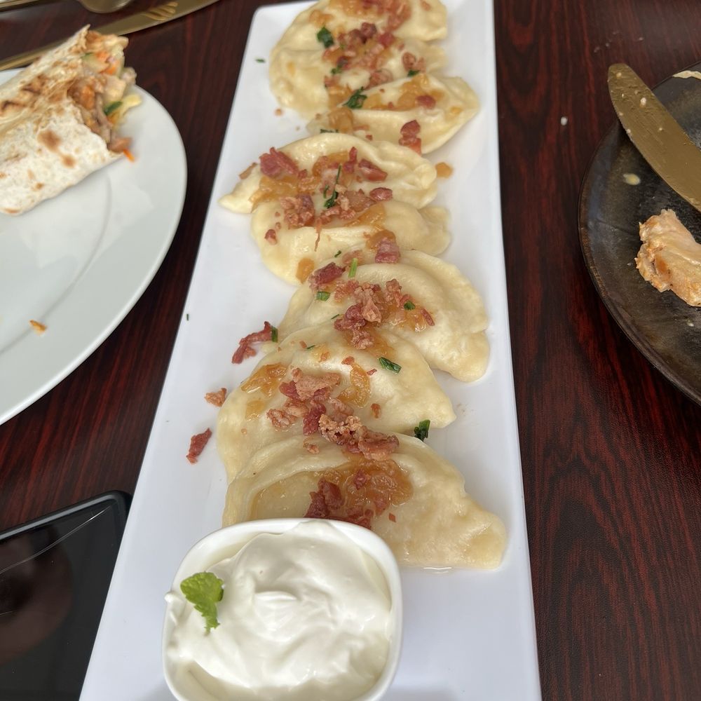Pal Man - Potato perogi with cooked onion and bacon on top and side of sour cream. - American Near Me - Federal Way, Washington Pal Man - Potato perogi with cooked onion and bacon on top and side of sour cream. - American Near Me - Federal Way, Washington