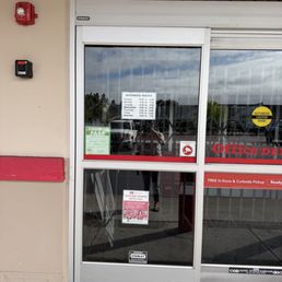 Doors closed at 8:55 a.m. on a Monday with a sign showing they open at 8 a.m. on Mondays