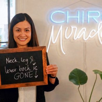 Source Chiropractic - Patient smiling and holding a sign reading 'Neck, leg & lower back is gone' at Source Chiropractic in downtown Toronto. - Chiropractors Near Me - Toronto, Ontario Source Chiropractic - Patient smiling and holding a sign reading 'Neck, leg & lower back is gone' at Source Chiropractic in downtown Toronto. - Chiropractors Near Me - Toronto, Ontario