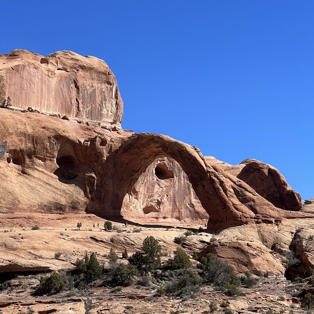 Corona Arch Trail - Corona Arch.  Notice the tiny people under it! - Hiking Near Me - Moab, Utah