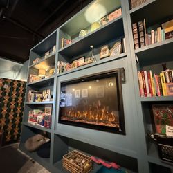 Kitty Corner Social Club - Fireplace screen with books and games