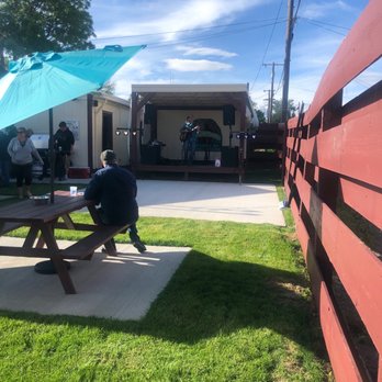 Little Chicago Club - a man sitting at a picnic table under an umbrella - Bars Near Me - Black Eagle, Montana Little Chicago Club - a man sitting at a picnic table under an umbrella - Bars Near Me - Black Eagle, Montana