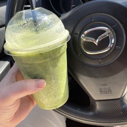 a hand holding a cup of green tea