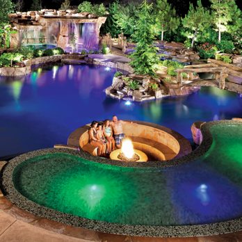 Blue Haven Pools & Spas - Lagoon-style concrete pool with integrated landscape pockets, sunken conversation area with fire pit, and multicolor LED lighting - Pool & Hot Tub Service Near Me - Morganville, New Jersey Blue Haven Pools & Spas - Lagoon-style concrete pool with integrated landscape pockets, sunken conversation area with fire pit, and multicolor LED lighting - Pool & Hot Tub Service Near Me - Morganville, New Jersey