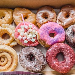 Thomas Donut & Snack Shop - A dozen variety including glazed, chocolate iced, cruller, strawberry, cinnamon bun, red velvet, chocolate twist, and chocolate cake donut.
