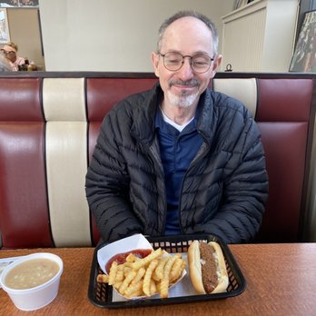 Kevin's Dog House - a man sitting at a table with a tray of hot dogs and french fries - Desserts Near Me - Virginia Beach, Virginia Kevin's Dog House - a man sitting at a table with a tray of hot dogs and french fries - Desserts Near Me - Virginia Beach, Virginia