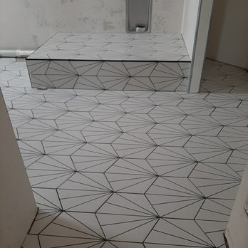 Azar’s Renovations  -  a bathroom with a tiled floor - General Contractors Near Me
