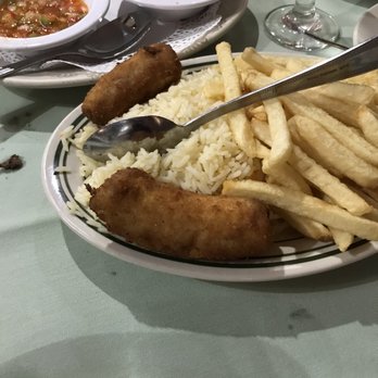 Fernandes steakhouse - Don't waste valuable tummy room on starch when ponying up $53 a head for unlimited meat! - A plate contains rice, French fries, and fried fish fillets, with side dishes of soup and a crumbly dish in bowls. - Portuguese Near Me - Newark, New Jersey