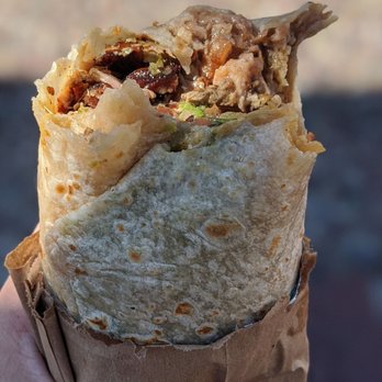 Los Compadres - a hand holding a burrito - Mexican Near Me - South San Francisco, California Los Compadres - a hand holding a burrito - Mexican Near Me - South San Francisco, California