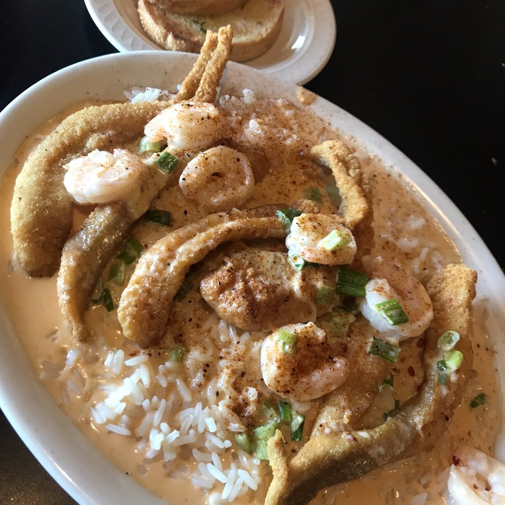 Rick's Crossroads Grille - Fried catfish with Cajun garlic shrimp sauce on a bed of rice - Steakhouses Near Me - Lincoln, Alabama Rick's Crossroads Grille - Fried catfish with Cajun garlic shrimp sauce on a bed of rice - Steakhouses Near Me - Lincoln, Alabama