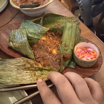 Chatti by Regi Mathew - Opening the Banana leaf parcel- fish with tomato and tamarind - Indian Near Me - New York, New York Chatti by Regi Mathew - Opening the Banana leaf parcel- fish with tomato and tamarind - Indian Near Me - New York, New York