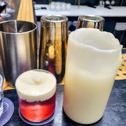 Danico - The Elotes cocktail next to a medium-sized candle.