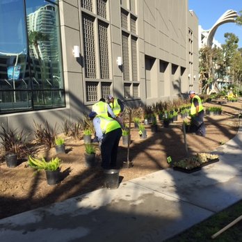Centrescapes - a man in a yellow vest working on a sidewalk - Irrigation Near Me - Pomona, California