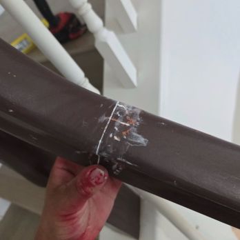CC Handyman Services - A person is holding a brown handrail with visible scratches, paint marks, and damage, with a staircase and tools in the background. - Plumbing Near Me - Riverside, California