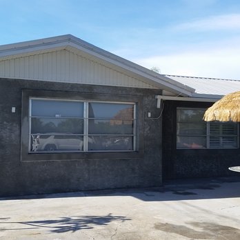 John Boone Construction - a house with a thatched umbrella - Stucco Services Near Me