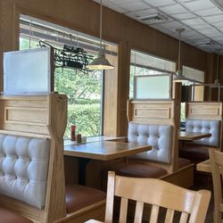 Gus' Pub And Pizzarama - Booths and wooden chairs and tables.