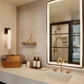 The Bower - The Bower's bathroom exudes spa-like elegance with brass fixtures, ambient lighting, and luxe amenities for a refined retreat - Hotels Near Me - Coronado, California The Bower - The Bower's bathroom exudes spa-like elegance with brass fixtures, ambient lighting, and luxe amenities for a refined retreat - Hotels Near Me - Coronado, California