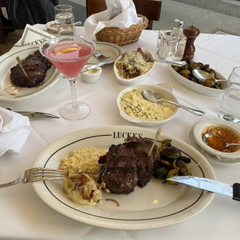Luckys Steakhouse - Bone-in Rib Chop, 18 oz. SLICED Bone-in Filet Mignon Fresh Creamed Corn Brussels sprouts Hashed Brown Potatoes with Gruyere Cheese - Steakhouses Near Me - Montecito, California Luckys Steakhouse - Bone-in Rib Chop, 18 oz. SLICED Bone-in Filet Mignon Fresh Creamed Corn Brussels sprouts Hashed Brown Potatoes with Gruyere Cheese - Steakhouses Near Me - Montecito, California