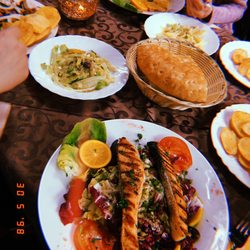 Plaka - vorne Salat mit Lachfilet, hinten links Plaka-Grillteller und hinten rechts Putenbrustfilet mit Sauce Bernaise