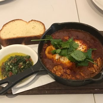 Honey & Co. - shakshuka (£9.50) - 2 Cornish farm eggs baked in a tomato sauce served with coriander zehug & milk bun - Middle Eastern Near Me - London, XGL