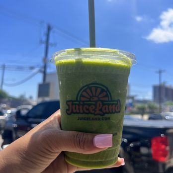 JuiceLand - a hand holding a green smoothie - Juice Bars & Smoothies Near Me - Houston, Texas