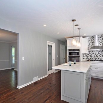 Gt Renovations - a kitchen with white cabinets and wood floors - General Contractors Near Me Gt Renovations - a kitchen with white cabinets and wood floors - General Contractors Near Me