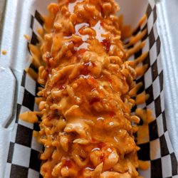 Kordog Korean Style Hotdog - Half cheese and half dog. Crunchy ramen coating with spicy mayo and sweet chili sauce.