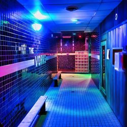 The Works - Neon-lit wet area with tiled walkways and lounge seating at The Works in Indianapolis.